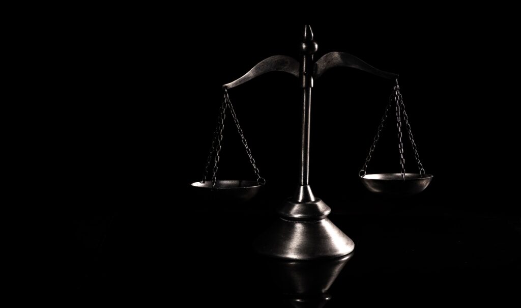 antique style metal balance scale featuring two opposing balance arms scales of justice
