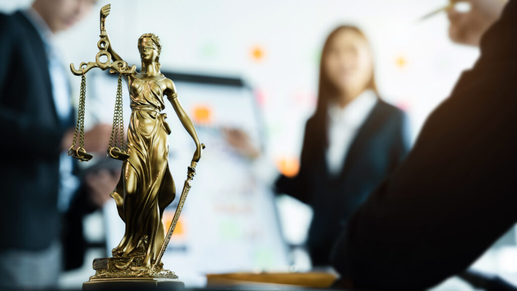 statue of justice with scales, the team meeting at the law firm